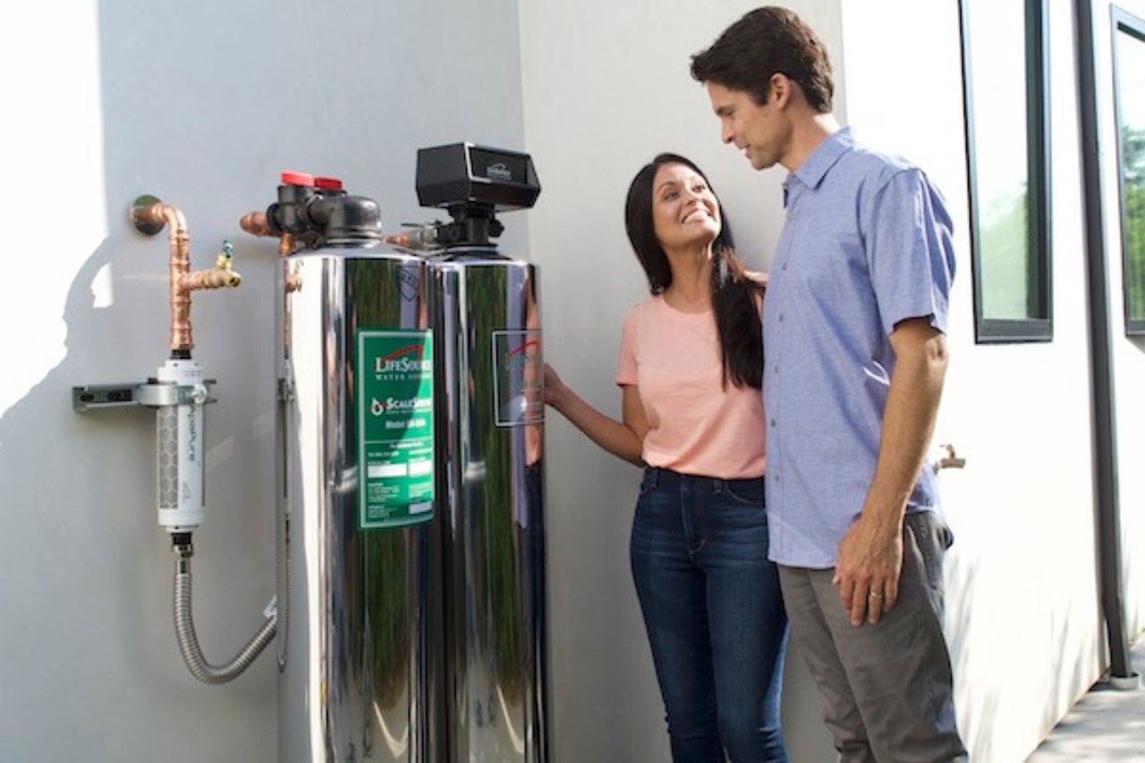 Couple standing by their whole house water system outside