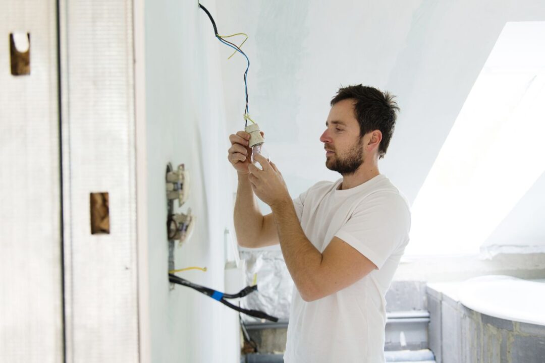 man installing a light bulb